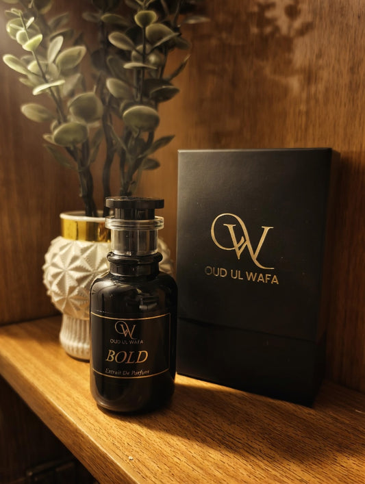 Oud Ul Wafa perfume bottle and packaging on a wooden surface with a plant in the background